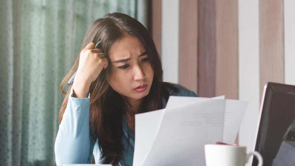 worried woman looking at documents